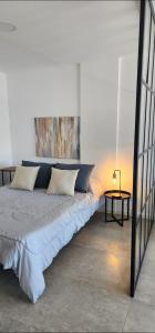 una cama con almohadas y una mesa en una habitación en Monoambiente premium Paso en Mar del Plata