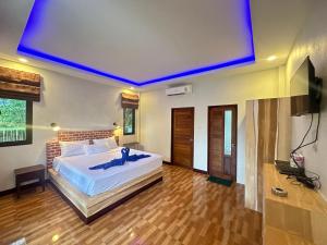 a bedroom with a large bed with a blue ceiling at Lanta Living bungalow in Ko Lanta