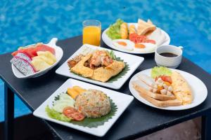 stół z czterema talerzami jedzenia w obiekcie Dong Talay Lipe Beach Resort w mieście Ko Lipe