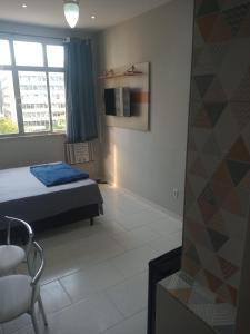 1 dormitorio con 1 cama, 1 silla y 1 ventana en Loft Aconchegante no Centro de Niterói!! en Niterói