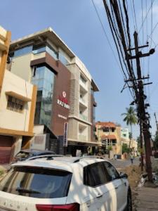 a white car parked in front of a building at Hotel Raj Inn Bhubaneswar in Bhubaneshwar