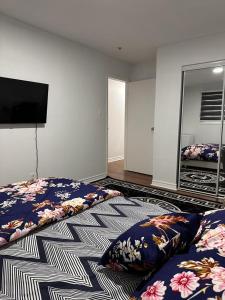 a bedroom with two beds and a flat screen tv at DARON HOMES in Brampton