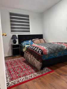 a bedroom with a bed and a rug on the floor at DARON HOMES in Brampton