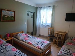 a small room with two beds and a window at Penzion Kelčany u Kyjova in Kelčany
