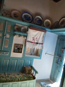 a room with a blue wall with plates and a bench at ARCHONTIKO Traditional House 1850 in Olympos