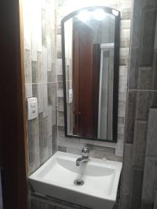 a bathroom sink with a large mirror above it at Loft Aconchegante no Centro de Niterói com AR-CONDICIONADO! in Niterói