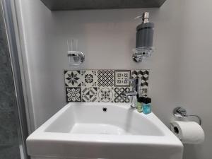 a white sink in a bathroom with tiles on the wall at Spacious Rooms - Perfect for Contractors Relocators Business Travellers Long Stay Discounts in Parkside