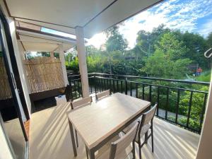 eine Veranda mit einem Tisch und Stühlen auf dem Balkon in der Unterkunft Lanta Living bungalow in Ko Lanta