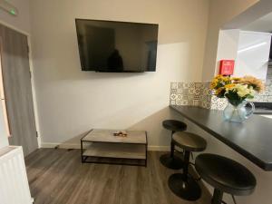 a room with two stools and a table with a tv at Spacious Rooms - Ideal for Contractors Relocators Business Travellers Long Stay Discounts in Parkside
