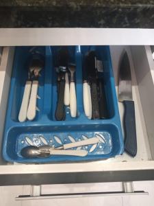una bandeja azul llena de utensilios en un cajón en Loft Aconchegante no Centro de Niterói!! en Niterói