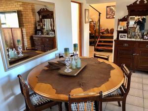 - une salle à manger avec une table, des chaises et un miroir dans l'établissement Aporto Villa, à Reebok