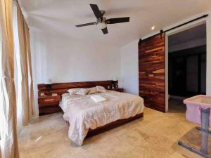 Schlafzimmer mit einem Bett und einem Deckenventilator in der Unterkunft Casa de campo con vista al atardecer y alberca in Estancia los López