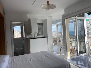 a white room with a bed and a balcony at Calle Manuel Mena 4 in Arroyo de la Miel