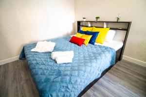 een slaapkamer met een bed met kleurrijke kussens bij AB Apart Business 35237 in Astana