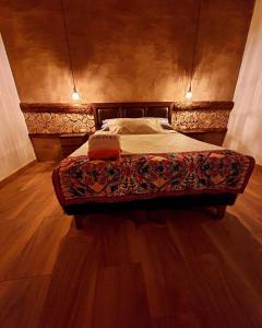 Cama en habitación con suelo de madera en HOSTAL DON FELIX, en San Pedro de Atacama