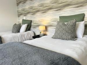 a bedroom with two beds with pillows and a wall at AuobCorner in Walvis Bay