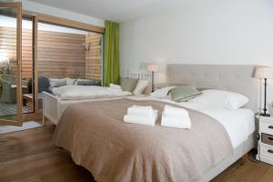 a bedroom with two towels on a large bed at Valmala holiday flat for 5 people and a family dog with fenced garden in Lenz