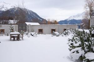 une maison avec une table dans la neige dans l'établissement Valmala holiday flat for 5 people and a family dog with fenced garden, à Lenz