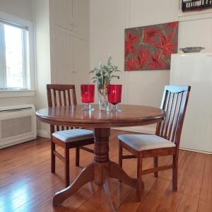 een houten tafel met twee wijnglazen en twee stoelen bij Morere cottage in Morere