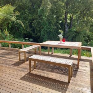 een houten picknicktafel en bank op een terras bij Morere cottage in Morere