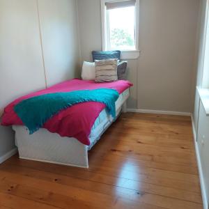 een slaapkamer met een bed met kleurrijke dekens en kussens bij Morere cottage in Morere