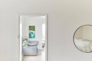 Camera bianca con specchio e sedia di Beachfront Apartment on Bondi to Bronte Walk a Sydney