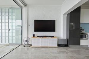 a living room with a flat screen tv on a wall at Beachfront Apartment on Bondi to Bronte Walk in Sydney