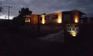 una casa con sus luces encendidas en la oscuridad en HOSTAL DON FELIX, en San Pedro de Atacama