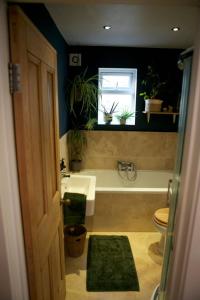 ein Badezimmer mit einer Badewanne, einem Waschbecken und einem WC in der Unterkunft Inviting & Secluded 1BD House w Patio - Peckham! in London