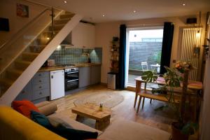 ein Wohnzimmer mit einem Sofa und einer Küche in der Unterkunft Inviting & Secluded 1BD House w Patio - Peckham! in London