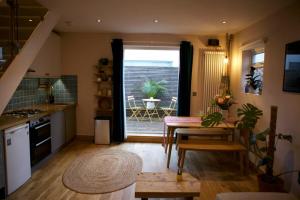 eine Küche und ein Esszimmer mit einem Tisch und einem Esszimmer in der Unterkunft Inviting & Secluded 1BD House w Patio - Peckham! in London