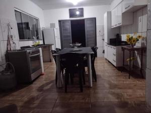 - une cuisine avec une table noire et des chaises dans l'établissement Pesqueiro & Chácara Moenda, à Itapetininga
