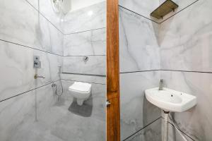 a white bathroom with a sink and a toilet at FabHotel Shree Khatu Shyam Palace in Indore