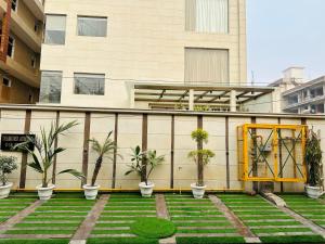 ein Gebäude mit Pflanzen davor in der Unterkunft Diamond Admire Hotel & Banquets by MMD in Noida