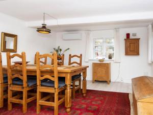 - une salle à manger avec une table et des chaises en bois dans l'établissement Holiday home Rømø CXXI, à Kongsmark