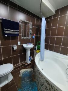 y baño con aseo, bañera y lavamanos. en Cozy apartment "Sam House", en Tashkent