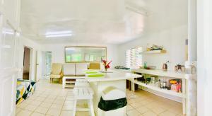 Tonga Cottage - Triple Room with Shared Facilities في Folaha: مطبخ مع طاولة وكراسي في غرفة