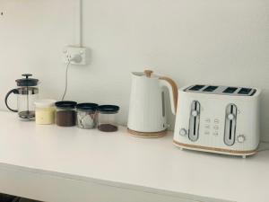 un mostrador con tostadora y otros electrodomésticos en Tonga Cottage - Triple Room with Shared Facilities en Folaha