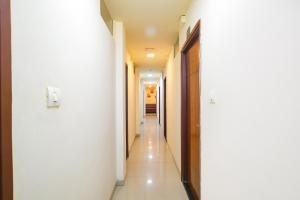 a hallway with white walls and white floors and doors at FabHotel Prithviraj in Indore