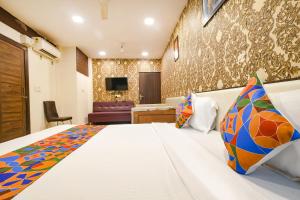 a hotel room with a bed and a living room at FabHotel Prithviraj in Indore