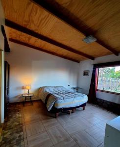 1 dormitorio con cama y ventana grande en HOSTAL DON FELIX, en San Pedro de Atacama