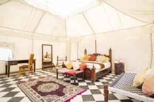 a bedroom with a bed and a table in a tent at Desert Signature Resorts in Sām