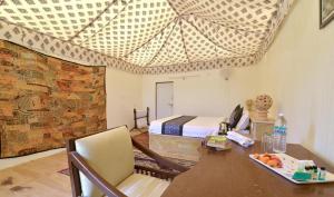 a bedroom with a bed and a desk with a table at Desert Signature Resorts in Sām