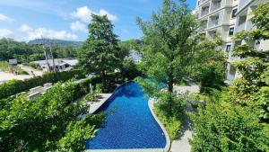 an overhead view of a swimming pool with trees and a building at Bright Apartment Close to Amazing Beach ! 39 Sqm in Nai Yang Beach