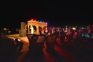a group of people sitting in chairs at night at Desert Signature Resorts in Sām