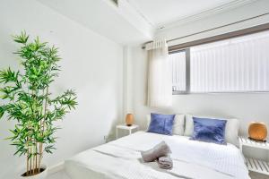 a bedroom with a bed with blue pillows and a plant at Superb 3 Bedroom Apartment Surry Hills in Sydney