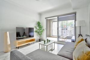 シドニーにあるSuperb 3 Bedroom Apartment Surry Hillsのリビングルーム(ソファ、薄型テレビ付)