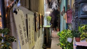 an alley with pictures on the side of a building at Huabing in Tainan