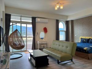 una camera con divano, letto e specchio di Holiday Homestay a Chishang