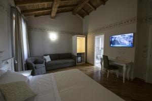 Un dormitorio con una cama, un sofá y un televisor. en Hotel Sesmones, en Lodi 37 fotos más
